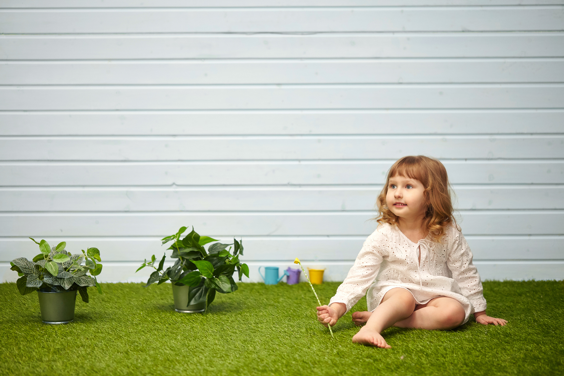 Kid playing and sitting on artificial grass - Orion Turf and Landscape