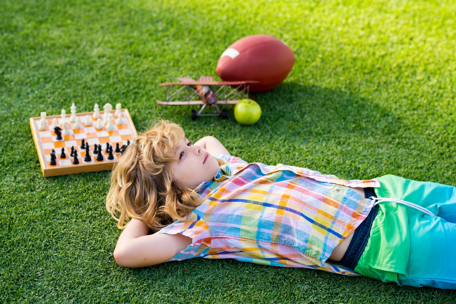 Kid laying on artificial grass - Orion Turf and Landscape