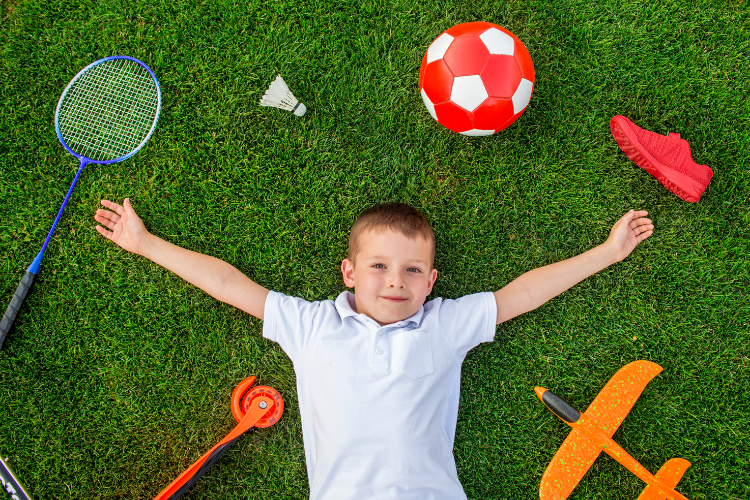 Kid laying on artificial grass - Orion Turf and Landscape