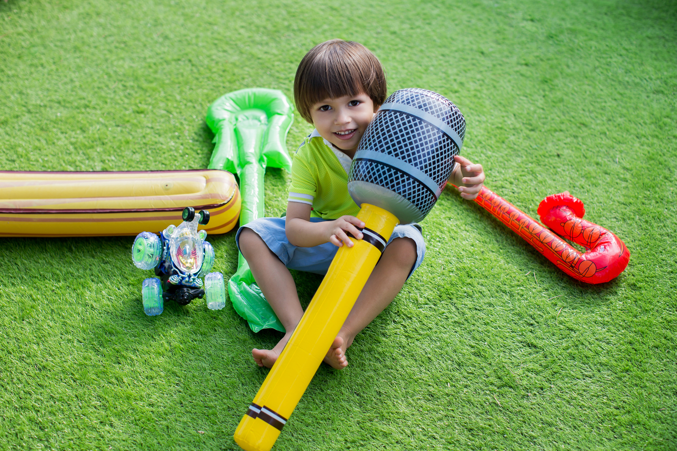 Kid with toy on artificial grass - Orion Turf and Landscape