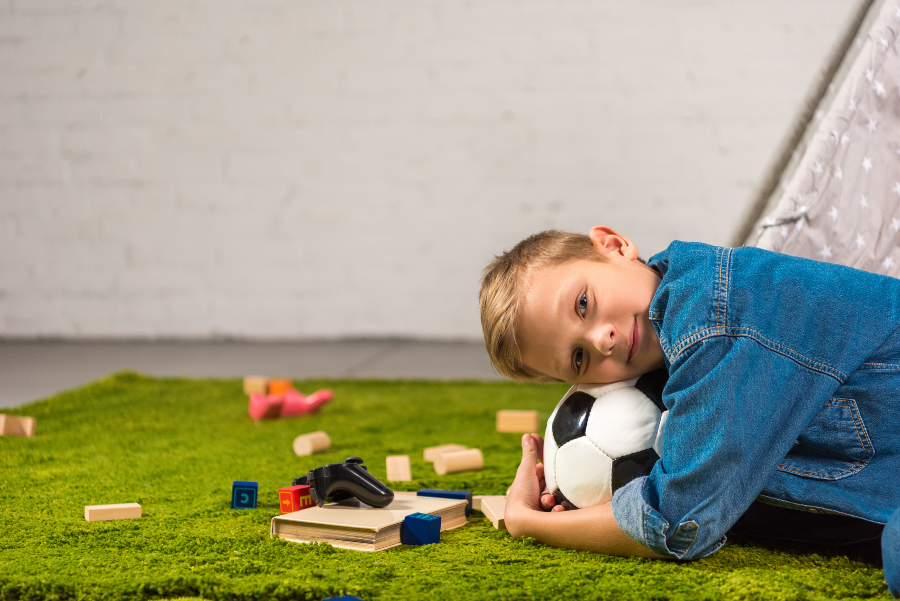 Kid with soccer ball on artificial grass - Orion Turf and Landscape