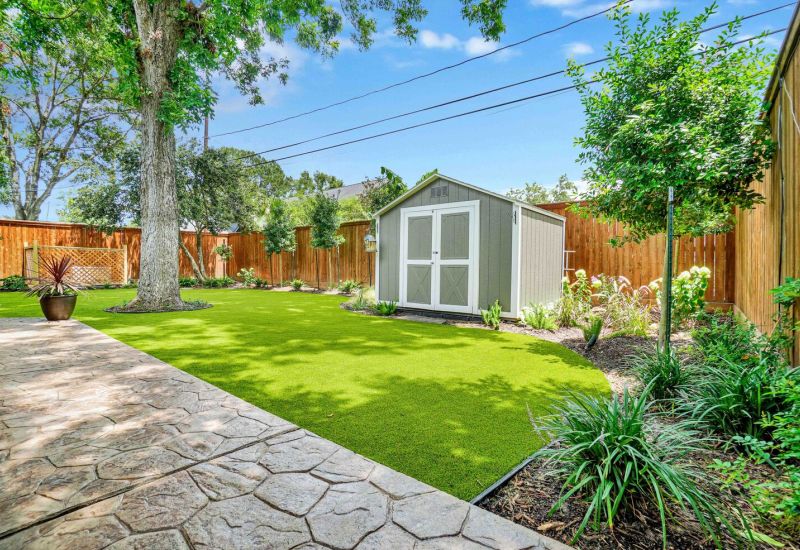 tool shed and sunny backyard made of artificial grass - Orion Turf and Landscape