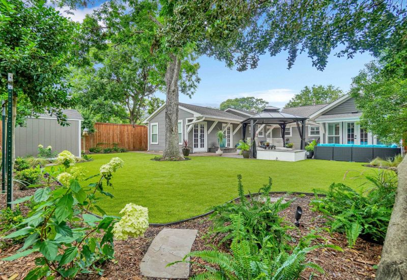 view of artificial grass in backyard with patio - Orion Turf and Landscape